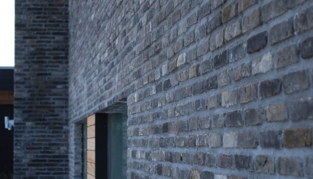 Mørk patinerede maskinrensede mursten giver bygningen et rustikt udtryk, perfekt til at skabe karakter i moderne og klassiske design.