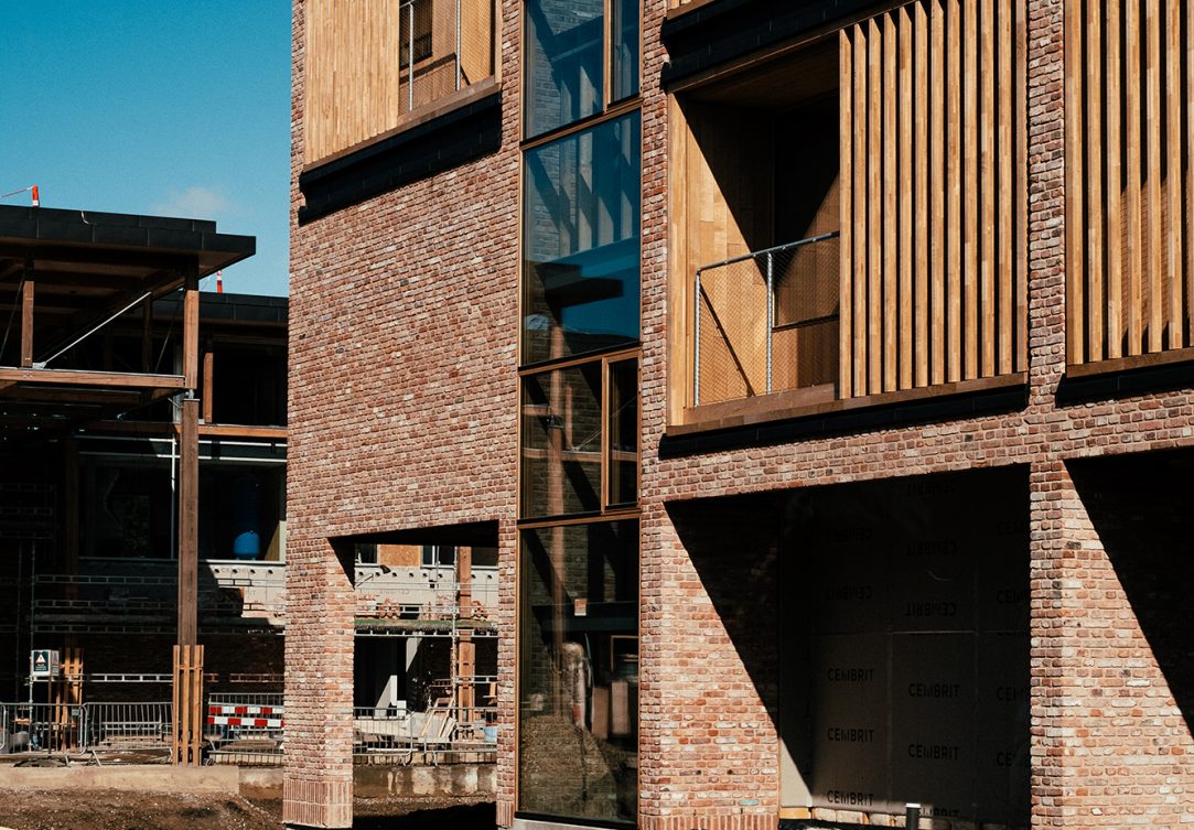 Røde maskinrensede mursten kombineret med træelementer ved Håndværkskolelgiet i Horsens.